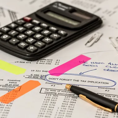 Calculator and biro on top of paper